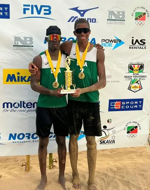Dominica's Under-21 men's beach volleyball team celebrating their victory at the ECVA Championship.